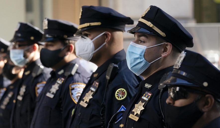 In this Oct. 5, 2020, photo, New York Police Department officers in masks stand during a service at St. Patrick&#39;s Cathedral in New York to honor 46 colleagues who have died due to COVID-19 related illness. New York City will require police officers, firefighters and other municipal workers to be vaccinated against COVID-19 or be placed on unpaid leave, Mayor Bill de Blasio said Wednesday, Oct. 20, 2021, giving an ultimatum to public employees who’ve refused and ensuring a fight with some of the unions representing them. (AP Photo/Mark Lennihan) **FILE**