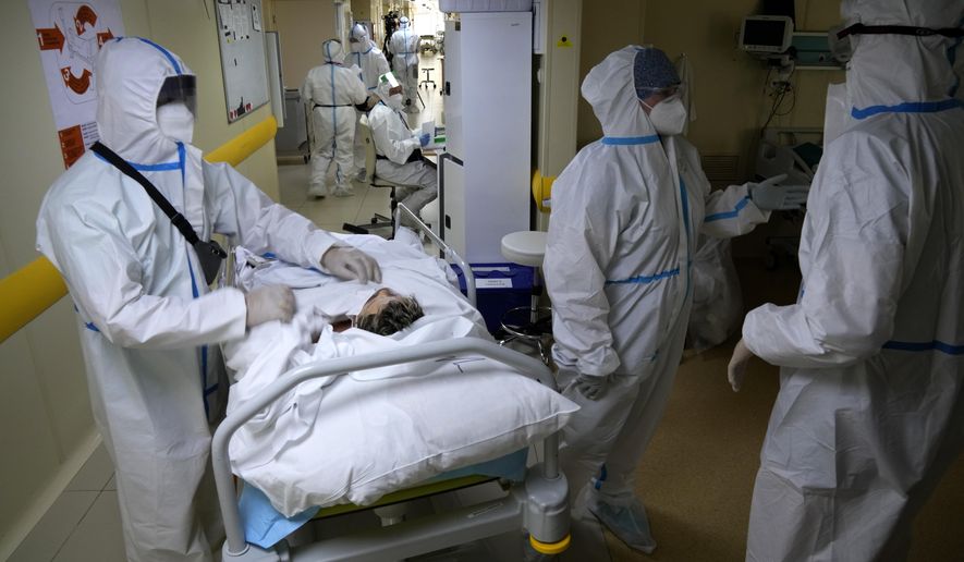 Medics wearing special suits to protect against the coronavirus prepare to move a patient with COVID-19 at an ICU at the Moscow City Clinical Hospital 52, in Moscow, Russia, Tuesday, Oct. 19, 2021. Russia hit another daily record of coronavirus deaths Tuesday as rapidly surging infection rates raised pressure on the country&#x27;s health care system and prompted the government to suggest declaring a nonworking week. (AP Photo/Alexander Zemlianichenko)