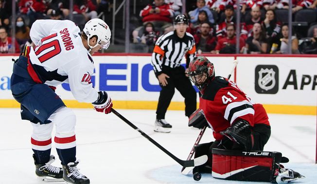 Washington Capitals&#x27; Daniel Sprong (10) shoots the puck past New Jersey Devils goaltender Scott Wedgewood (41) for a goal during the second period of an NHL hockey game Thursday, Oct. 21, 2021, in Newark, N.J. (AP Photo/Frank Franklin II)