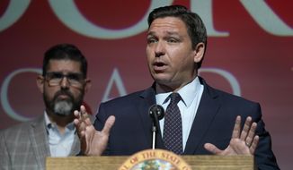In this Tuesday, Sept. 14, 2021, file photo, Florida Gov. Ron DeSantis speaks at the Doral Academy Preparatory School in Doral, Fla. Florida filed suit against President Joe Biden&#39;s administration Tuesday, Sept. 28, 2021, claiming his immigration policy is illegal, and DeSantis signed an order barring state agencies from assisting with the relocation of undocumented immigrants arriving in the state. (AP Photo/Wilfredo Lee. File)