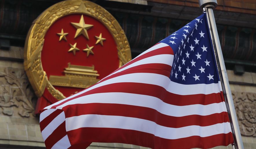 In this Nov. 9, 2017, file photo, an American flag is flown next to the Chinese national emblem during a welcome ceremony for visiting U.S. U.S. officials are issuing new warnings about China’s ambitions in artificial intelligence and a range of advanced technologies that could eventually give Beijing a decisive military edge and possible dominance over health care and other essential sectors in America. (AP Photo/Andy Wong, File)