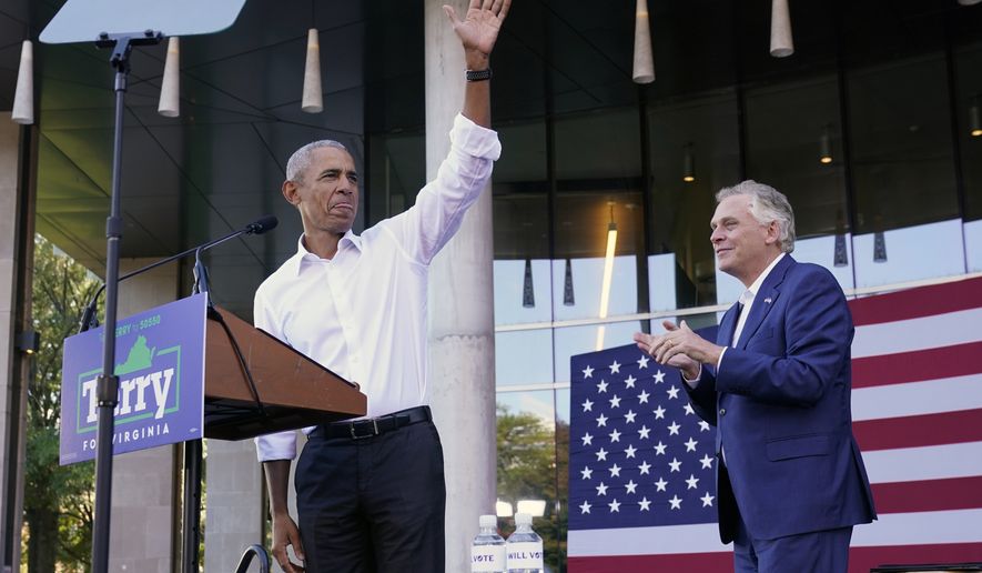 Former President Barack Obama, left, waves during a rally with Democratic gubernatorial candidate, former Virginia Gov. Terry McAuliffe, right, in Richmond, Va., Saturday, Oct. 23, 2021. McAuliffe will face Republican Glenn Youngkin in the November election. (AP Photo/Steve Helber)