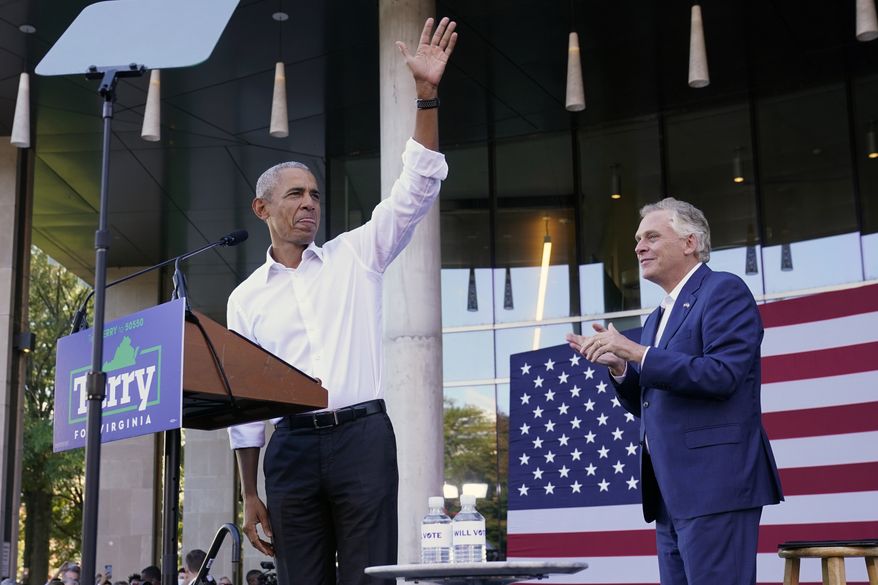 Former President Barack Obama, left, waves during a rally with Democratic gubernatorial candidate, former Virginia Gov. Terry McAuliffe, right, in Richmond, Va., Saturday, Oct. 23, 2021. McAuliffe will face Republican Glenn Youngkin in the November election. (AP Photo/Steve Helber)