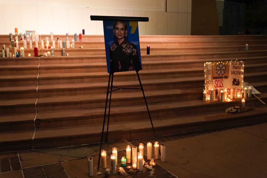 Candles are lit around a photo of cinematographer Halyna Hutchins during a candlelight vigil in Albuquerque, N.M., Saturday, Oct. 23, 2021. Hutchins died on Thursday after she was fatally shot by actor Alec Baldwin with a prop gun on a New Mexico film set. (AP Photo/Jae C. Hong)