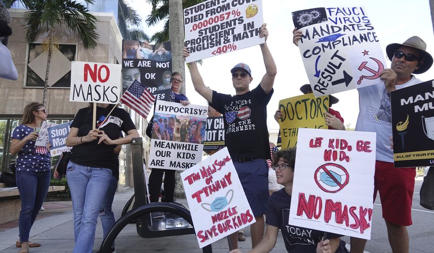 In this file photo, anti-mask protesters demonstrate outside of a Broward County School Board meeting, Tuesday, Oct. 5, 2021, in Fort Lauderdale, Fla. The National School Boards Association issued an apology late Friday for urging federal authorities to target unruly school board meetings, a missive that spurred Attorney General Merrick Garland’s much-decried decision to bring in the FBI.  (Joe Cavaretta/South Florida Sun-Sentinel via AP)  **FILE**