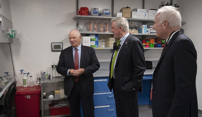 U.S. Sen. Ben Cardin, D-Md, left, U.S. Rep. David Trone, D-6th-Md., center, and Seth Lederman, Tonic CEO, chat in a lab area of the Tonix Pharmaceuticals facility following a ribbon-cutting ceremony, Monday, Oct. 18, 2021 in Frederick, Md. With the snip of a ribbon on a windy Monday afternoon, Tonix Pharmaceuticals officially has a research and development center for infectious diseases — and it’s located in Frederick, right down the road from the city’s municipal airport. (Bill Green/The Frederick News-Post via AP) ** FILE **