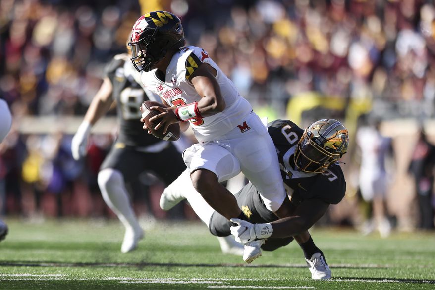 Maryland quarterback Taulia Tagovailoa (3) avoids a tackle by Minnesota defensive lineman Esezi Otomewo (9) during an NCAA college football game Saturday, Oct. 23, 2021, in Minneapolis. (AP Photo/Stacy Bengs)