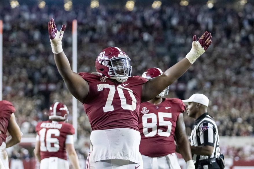 Alabama offensive lineman Javion Cohen (70) signals a touchdown after a dive into the end zone by quarterback Bryce Young during the second half of an NCAA college football game against Tennessee, Saturday, Oct. 23, 2021, in Tuscaloosa, Ala. (AP Photo/Vasha Hunt) **FILE**