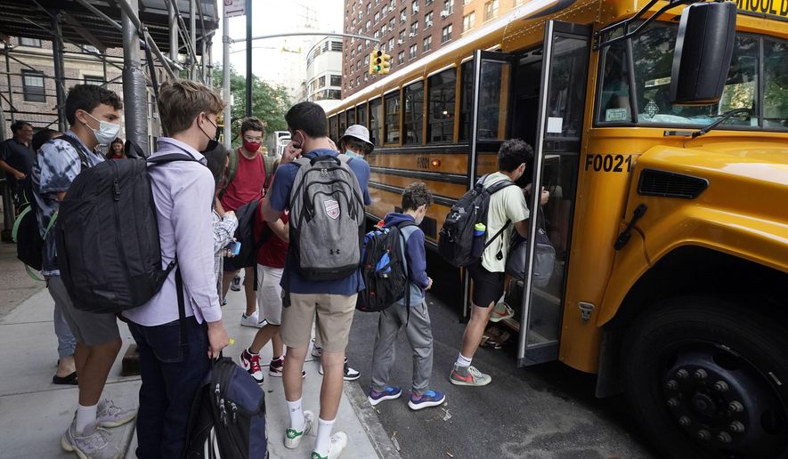 In this Sept. 13, 2021, file photo, students board a school bus on New York&#39;s Upper West Side. Even as most students return to learning in the classroom this school year, disruptions to in-person learning, from missing one day because of a late school bus to an entire two weeks at home due to quarantine, remain inevitable as families and educators navigate the ongoing pandemic. (AP Photo/Richard Drew, File)