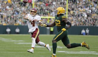 Washington Football Team&#39;s Taylor Heinicke throws with Green Bay Packers&#39; Rashan Gary defending during the second half of an NFL football game Sunday, Oct. 24, 2021, in Green Bay, Wis. (AP Photo/Aaron Gash)