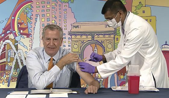 In this image from video, New York Mayor Bill de Blasio, left, receives a COVID-19 Moderna vaccine booster from New York City Health Commissioner Dr. Dave Chokshi, during the mayor&#x27;s daily news briefing, Monday, Oct, 25, 2021. New York Gov. Kathy Hochul and Mayor Bill de Blasio each received COVID-19 boosters Monday as part of their efforts to promote widespread vaccinations. (Office of the New York Mayor via AP)