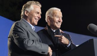 President Joe Biden, right, reacts after speaking at a rally for Democratic gubernatorial candidate, former Virginia Gov. Terry McAuliffe, Tuesday, Oct. 26, 2021, in Arlington, Va. McAuliffe will face Republican Glenn Youngkin in the November election. (AP Photo/Alex Brandon)