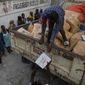 A worker stands on a truckload of corn flakes donated from the AAA political party to residents in the gang-controlled Bel Air neighborhood of Port-au-Prince, Haiti, Tuesday, Oct. 5, 2021. (AP Photo/Rodrigo Abd) ** FILE **