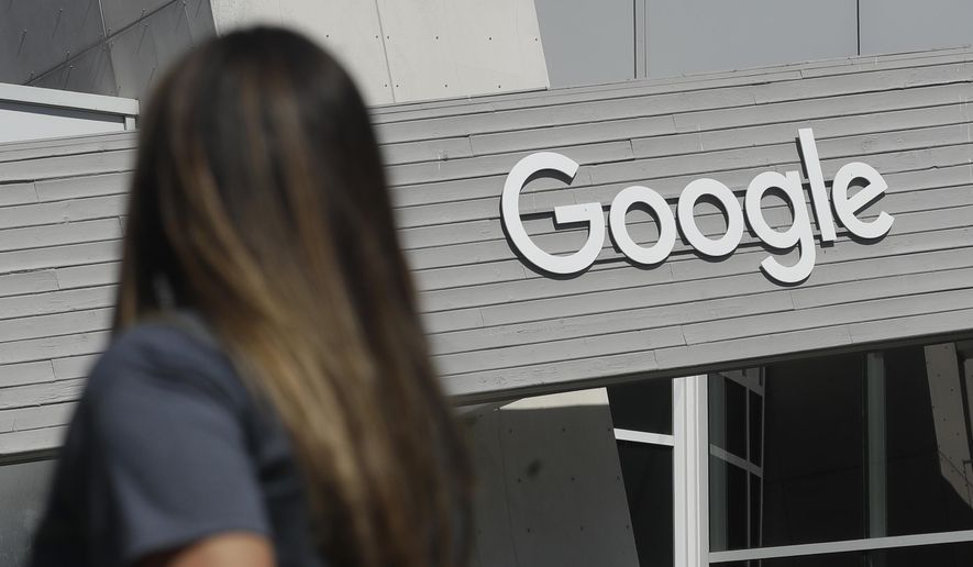 In this Sept. 24, 2019, photo, a woman walks below a Google sign on the campus in Mountain View, Calif. (AP Photo/Jeff Chiu) **FILE**