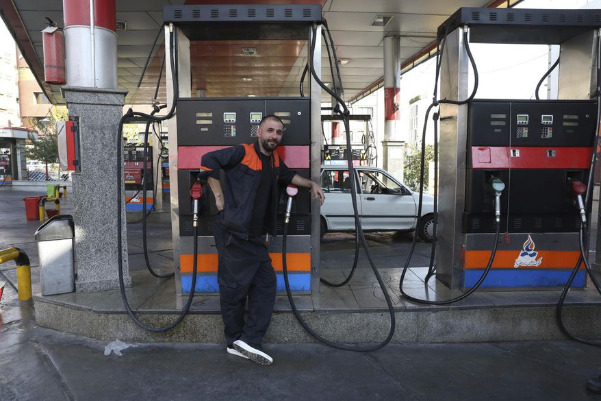 A worker leans against a gasoline pump that has been turned off, at a gas station in Tehran, Iran, Tuesday, Oct. 26, 2021. Gas stations across Iran on Tuesday suffered through a widespread outage of a system that allows consumers to buy fuel with a government-issued card, stopping sales. One semiofficial news agency referred to the incident as a cyberattack. (AP Photo/Vahid Salemi)
