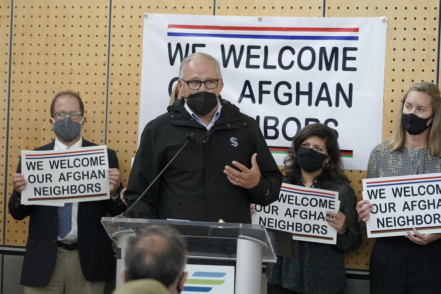 FILE - Washington Gov. Jay Inslee speaks during a news conference at the Afghan Welcome Center at the Seattle-Tacoma International Airport in Seattle, in this Friday, Oct. 22, 2021, file photo. Ordinary Americans and the nation&#39;s airlines are combining to donate miles and cash to help Afghan refugees resettle in the United States. Organizers said Tuesday, Oct. 26, 2021, they have raised enough donations pay for 40,000 flights, but they&#39;re hoping to nearly double that amount.(AP Photo/Ted S. Warren, File)