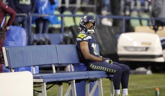 Seattle Seahawks&#39; Tyler Lockett sits on the bench after his team lost to the New Orleans Saints in an NFL football game, Monday, Oct. 25, 2021, in Seattle. (AP Photo/Ted S. Warren)