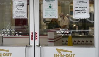 In this Oct. 20, 2021, file photo, signs advising vaccination and face mask requirements and no indoor dining are displayed on the door of an In-N-Out restaurant in San Francisco&#39;s Fisherman&#39;s Wharf. The restaurant&#39;s indoor dining was shut down this month by health authorities for not demanding proof of vaccination. (AP Photo/Jeff Chiu, File)