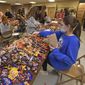 In this file photo, a high school student bags candy at the Richland Township Police Department in Johnstown, Pa., Wednesday, Oct. 27, 2021, for their Trick or Treat night to be held the next day.  (John Rucosky/The Tribune-Democrat via AP)  **FILE**