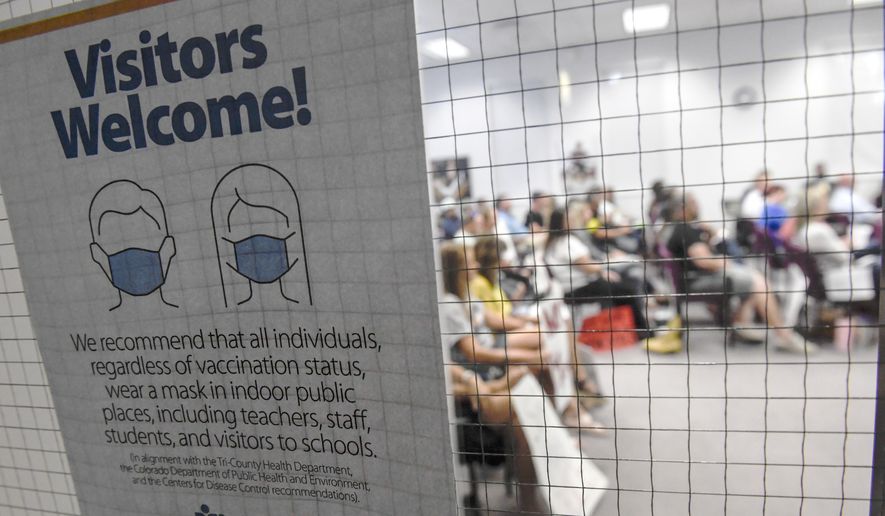 In this Aug. 24, 2021, photo, a Douglas County School District sign asks people to wear masks during a Board of Education meeting in Castle Rock, Colo., to discuss the use of masks and other protective measures in Douglas County Schools. A federal judge issued a restraining order Tuesday, Oct. 26, 2021, against the suburban Denver county&#39;s policy allowing parents to opt their children out of a mask mandate at schools, finding that the rule violates the rights of students with disabilities who are vulnerable to COVID-19. (Aaron Ontiveroz/The Denver Post via AP) **FILE**