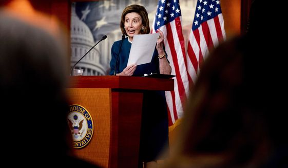 House Speaker Nancy Pelosi of Calif., holds up a paper as she speaks during a news conference on Capitol Hill in Washington, Thursday, Oct. 28, 2021. (AP Photo/Andrew Harnik)