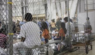 In this June 17, 2018, photo provided by U.S. Customs and Border Protection, people who&#39;ve been taken into custody related to cases of illegal entry into the United States, sit in one of the cages at a facility in McAllen, Texas. The U.S. Justice Department is in talks to pay hundreds of thousands of dollars to each child and parent who was separated under a Trump-era practice of splitting families at the border.  A person familiar with the talks tells The Associated Press that figure was under consideration but changed, though not dramatically. The person spoke on condition of anonymity because discussions are private. About 5,500 children were split from their parents under the practice. (U.S. Customs and Border Protection&#39;s Rio Grande Valley Sector via AP) **FILE**