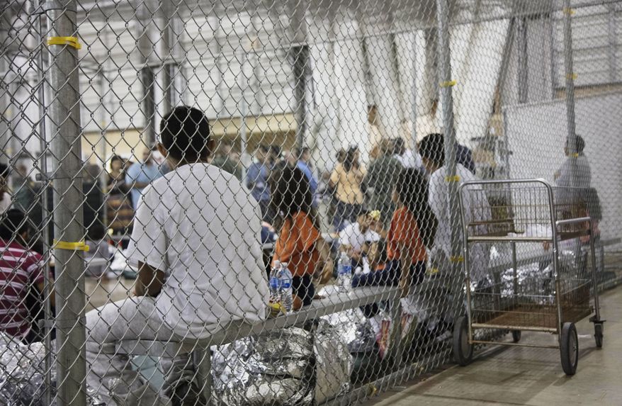 In this June 17, 2018, photo provided by U.S. Customs and Border Protection, people who&#39;ve been taken into custody related to cases of illegal entry into the United States, sit in one of the cages at a facility in McAllen, Texas. The U.S. Justice Department is in talks to pay hundreds of thousands of dollars to each child and parent who was separated under a Trump-era practice of splitting families at the border.  A person familiar with the talks tells The Associated Press that figure was under consideration but changed, though not dramatically. The person spoke on condition of anonymity because discussions are private. About 5,500 children were split from their parents under the practice. (U.S. Customs and Border Protection&#39;s Rio Grande Valley Sector via AP) **FILE**