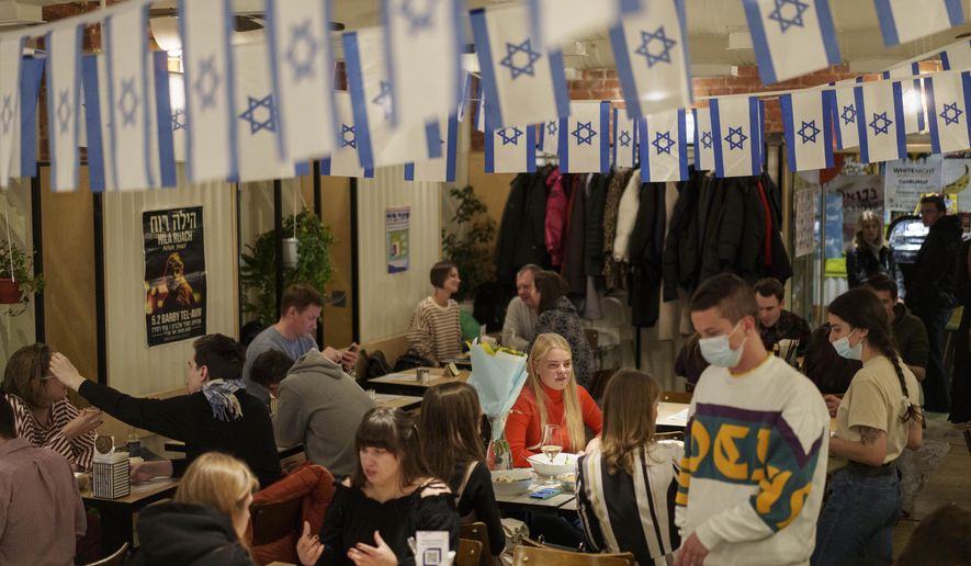 Customers sit in the Dizengof/99 restaurant in Moscow, Russia, Wednesday, Oct. 27, 2021. Officials in Moscow ordered a shutdown period to begin Thursday, with gyms, most entertainment venues, stores and schools to be closed for 11 days. Restaurants and cafes will only be open for takeout or delivery orders, leaving food stores and pharmacies to continue to stay open during the period. (AP Photo/Pavel Golovkin)