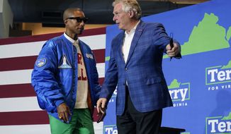 Recording artist Pharrell Williams, left, greets Democratic gubernatorial candidate former Gov. Terry McAuliffe during a rally in Norfolk, Va., Friday, Oct. 29, 2021. McAuliffe will face Republican Glenn Youngkin in the November election. (AP Photo/Steve Helber)