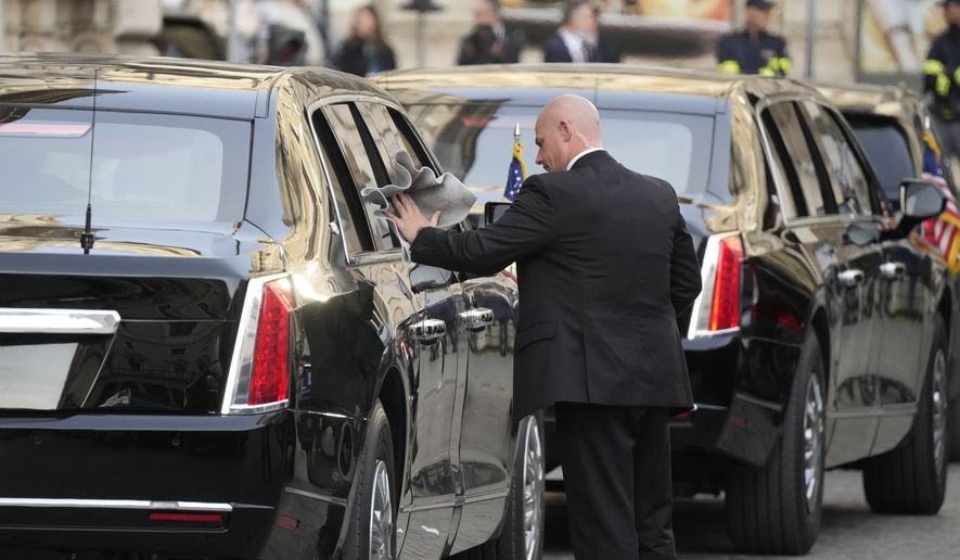 A driver polishes a window of a car in the motorcade of U.S. President Joe Biden as he waits outside the Chigi Palace in Rome, Friday, Oct. 29, 2021. A Group of 20 summit scheduled for this weekend in Rome is the first in-person gathering of leaders of the world&#39;s biggest economies since the COVID-19 pandemic started. (AP Photo/Gregorio Borgia)