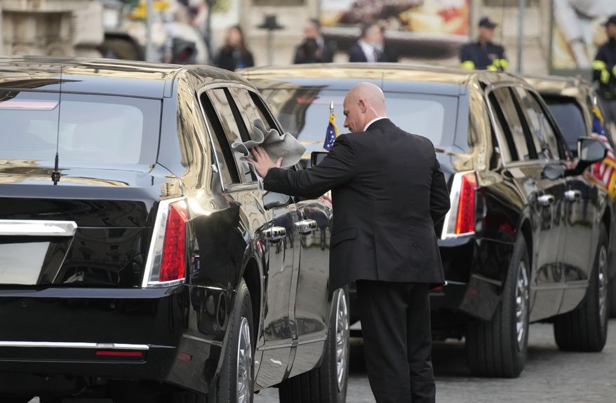 A driver polishes a window of a car in the motorcade of U.S. President Joe Biden as he waits outside the Chigi Palace in Rome, Friday, Oct. 29, 2021. A Group of 20 summit scheduled for this weekend in Rome is the first in-person gathering of leaders of the world&#x27;s biggest economies since the COVID-19 pandemic started. (AP Photo/Gregorio Borgia)