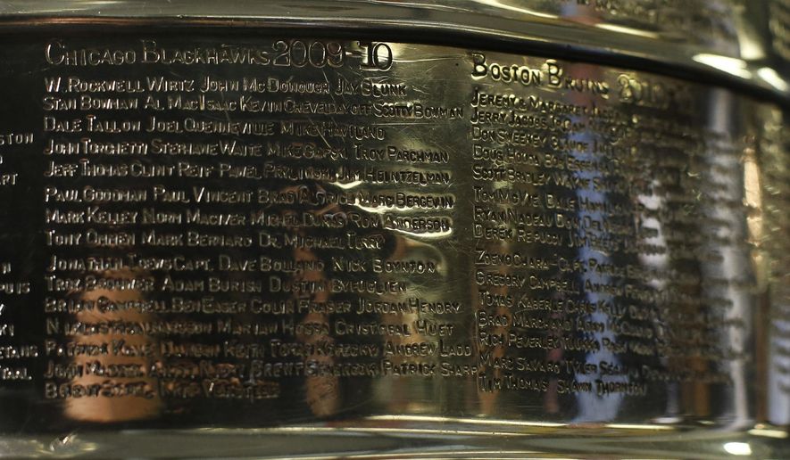 FILE - The names of the 2010 Stanley Cup Champion Chicago Blackhawks, left, are displayed on the Stanley Cup in the lobby of the United Center during an NHL hockey news conference on June 11, 2013 in Chicago. The first game of the Stanley Cup final series is Wednesday in Chicago. Blackhawks owner Rocky Wirtz wants the Hockey Hall of Fame to cover the name of an assistant coach engraved on the Stanley Cup after the assistant was accused of sexually assaulting a player during the team&#x27;s run to the 2010 championship. (AP Photo/Charles Rex Arbogast, File)