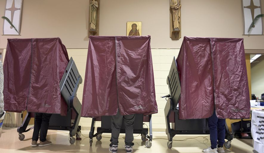 FILE - In this Tuesday, Nov. 3, 2020 file photo, Voters occupy booths at St. Maria Goretti Church, where five voting precincts are located, as polls open for Election Day in New Orleans. After a five-week postponement, early voting begins Saturday, Oct. 30, 2021 in Louisiana’s hurricane-delayed fall election, with four constitutional amendments the only thing facing all voters statewide.(Max Becherer/The Advocate via AP, File)