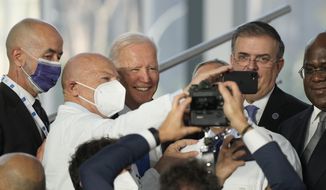 U.S. President Joe Biden poses for a selfie with medical personnel and other world leaders during a group photo at the La Nuvola conference center for the G20 summit in Rome, Saturday, Oct. 30, 2021. The two-day Group of 20 summit is the first in-person gathering of leaders of the world&#39;s biggest economies since the COVID-19 pandemic started. (AP Photo/Gregorio Borgia)