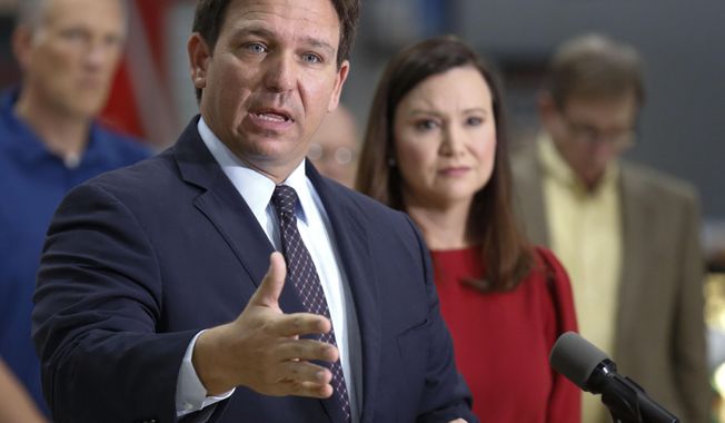 In this file photo, Florida Governor Ron DeSantis flanked by Attorney General Ashley Moody and supporters addresses the media and supporters Thursday, Oct. 28, 2021 in Lakeland Fla.  (Calvin Knight/The Ledger via AP)  **FILE**