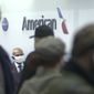 People wait in line at an American Airlines counter at an airport in Charlotte, N.C. on Sunday, Oct. 31, 2021. The airline has canceled more than 800 flights on Sunday, or nearly 30% of its schedule for the day. (WSOC-TV via AP)