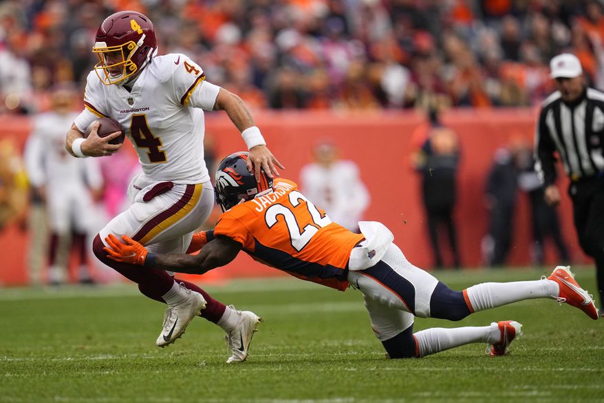 Washington Football Team quarterback Taylor Heinicke (4) is hit by Denver Broncos safety Kareem Jackson (22) during the first half of an NFL football game, Sunday, Oct. 31, 2021, in Denver. (AP Photo/Jack Dempsey)