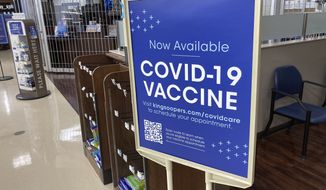 In this Saturday, Oct. 23, 2021, photograph, a sign notifies customers that COVID-19 vaccinations are available at a pharmacy in a grocery store in Monument, Colo. Companies with at least 100 workers will be required to give employees paid time off to get vaccinated against COVID-19 and paid sick leave if they have side effects from the shots. That&#39;s according to a Biden administration official who spoke Monday, Nov. 1,  about pending vaccine-mandate rules from OSHA, the Occupational Safety and Health Administration. (AP Photo/David Zalubowski) **FILE**
