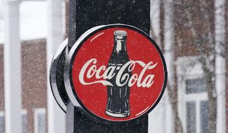 A Coca-Cola sign hangs outside a Coca-Cola distributor, Tuesday, Feb. 9, 2021, in Bedford, Ohio. Coca-Cola has completed its acquisition of sports drink brand BodyArmor. Coke said Monday, Nov. 1,  it paid $5.6 billion for the remaining 85% of the sports beverage company.   (AP Photo/Tony Dejak, File)