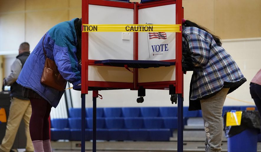 Caution tape closes off a voting stall to help distance voters to help prevent the spread of the coronavirus during Election Day at the East End School, Tuesday, Nov. 3, 2020, in Portland, Maine. (AP Photo/Robert F. Bukaty, File)