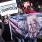 A supporter of Republican gubernatorial candidate Glenn Youngkin displays a flag showing Presidents Donald Trump, Ronald Reagan and Abe Lincoln at a campaign rally in Leesburg, Va., Monday, Nov. 1, 2021. Youngkin faces Democratic gubernatorial candidate former Gov. Terry McAuliffe in the Nov. 2, election. (AP Photo/Cliff Owen) **FILE**
