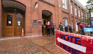 Voters arrive to cast the their ballots on Election Day at City Hall, Tuesday, Nov. 2, 2021 in Alexandria, Va. Voters are deciding between Democrat Terry McAuliffe and Republican Glenn Youngkin for governor. (AP Photo/Alex Brandon)