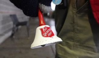 A Salvation Army bell is rung by Michael Cronin as he staffs the charity&#39;s red donation kettle in front of a grocery store, Tuesday, Dec. 8, 2020, in Lynden, Wash. An advocacy group organized in February to &quot;combat critical race theory&quot; said it will continue its battle of words with The Salvation Army, promising to fire a barrage of social media advertisements asking the charity to say America isn&#39;t racist. (AP Photo/Elaine Thompson, File)
