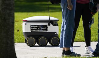 Robots navigate the Bowling Green State University campus in Bowling Green, Ohio, on Thursday, Oct. 13, 2021. Robot food delivery is no longer the stuff of science fiction. Hundreds of little robots — knee-high and able to hold around four large pizzas — are now navigating college campuses and even some city sidewalks in the U.S., the U.K. and elsewhere. (AP Photo/Carlos Osorio) ** FILE **