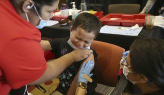 Romeo Posada, 8, of Mercedes, Texas grimaces as he gets ready to receive the Pfizer-BioNTech COVID-19 vaccine for children five to 12 years at Edinburg Conference Center at Renaissance on Wednesday Nov., 3, 2021 in Edinburg, Texas. (Delcia Lopez/The Monitor via AP)