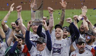 Atlanta Braves manager Brian Snitker hoists the trophy as first baseman Freddie Freeman cheers after the Braves won the baseball World Series with a win over the Houston Astros in Game 6 of the series, Tuesday, Nov. 2, 2021, in Houston. (Kevin M. Cox/The Galveston County Daily News via AP)