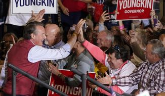 Republican gubernatorial candidate Glenn Youngkin, left, greets a supporter during a rally in Chesterfield, Va., Monday, Nov. 1, 2021. Youngkin will face Democrat former Gov. Terry McAuliffe in the November election. (AP Photo/Steve Helber)