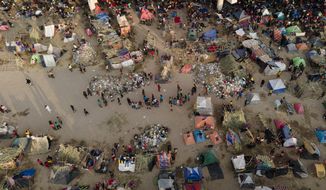Migrants, many from Haiti, are seen at an encampment along the Del Rio International Bridge near the Rio Grande, Sept. 21, 2021, in Del Rio, Texas. About 15,000 mostly Haitian refugees were camped under the bridge in the small border town. (AP Photo/Julio Cortez) ** FILE **