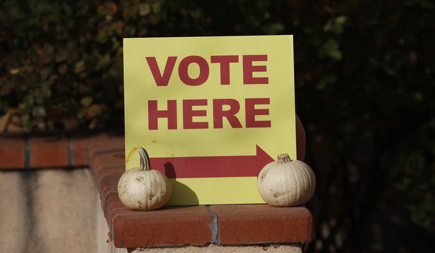 A sign directs voters to the entrance of a polling station at the St. John&#39;s United Methodist Church on Tuesday, Nov. 2, 2021, in Santa Fe, New Mexico. Voters cast ballots in municipal elections across the state, including for mayoral races and school funding measures. (AP Photo/Cedar Attanasio)