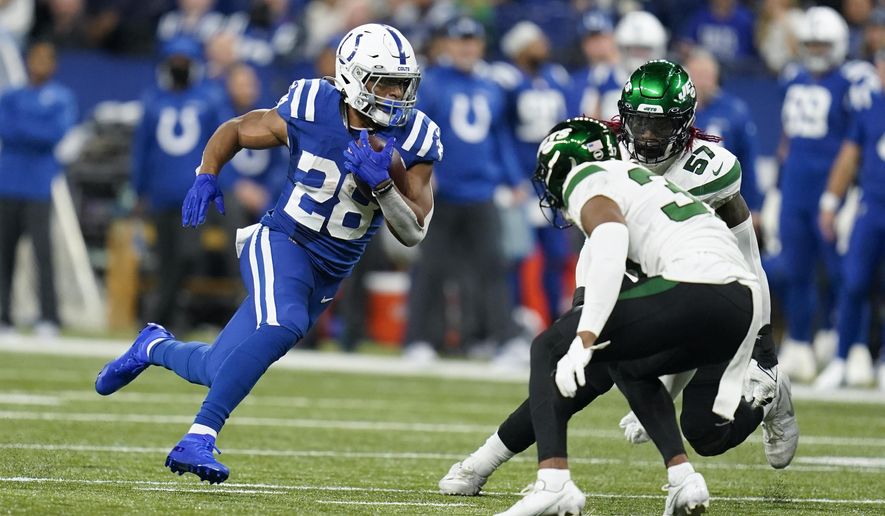 Indianapolis Colts&#39; Jonathan Taylor (28) runs against New York Jets&#39; Bryce Hall (37) during the first half of an NFL football game, Thursday, Nov. 4, 2021, in Indianapolis. (AP Photo/Michael Conroy)